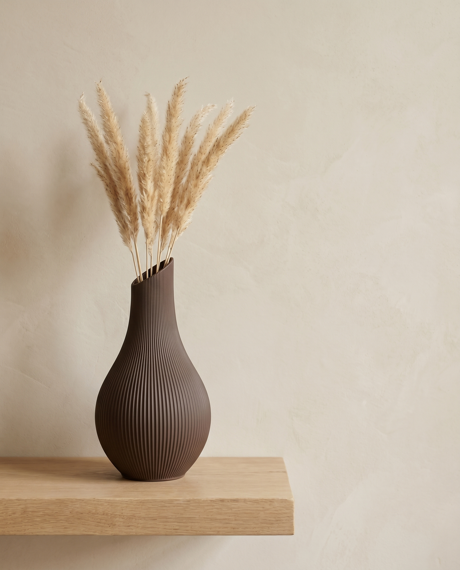 Vase Yazu in Braun mit Pampasgras, Look auf Holzbrett vor warmer Wand